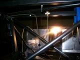 The brake line runs in front of the second rail at the front of the car and loops down, into the bottom of the drilled T-piece